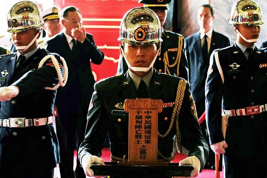 A honor guard (centre) holds a soldiers' tablet during a ceremony to honor the dead soldiers of Taiwan killed in Myanmar during World War II, at the Martyr's Shrine in Taipei on Aug 27, 2014.&nbsp;Taiwan on Wednesday honoured tens of thousands of Kuo