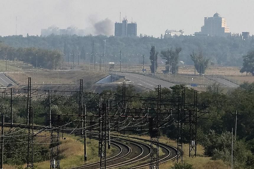 Smoke rises after shelling during fighting between militants and Ukrainian forces in Donetsk on Aug 27, 2014.&nbsp;Russian-backed separatists have taken the strategic high point of Savur-Mohyla in eastern Ukraine, which looks out over wide areas of t