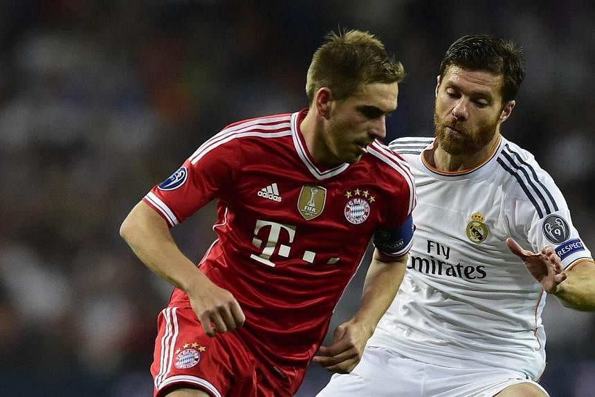 Real Madrid midfielder Xabi Alonso (right) battles Bayern Munich defender Philipp Lahm (left) for the ball during the UEFA Champions League semifinal first leg football match at the Santiago Bernabeu stadium in Madrid on April 23, 2014&nbsp;.&nbsp;Ge