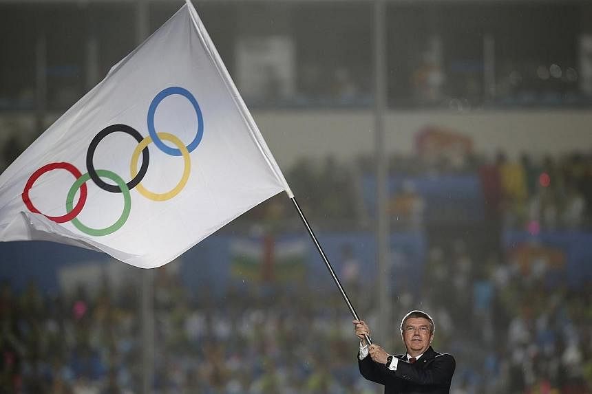 International Olympic Committee (IOC) President Thomas Bach waves the Olympic flag during the closing ceremony of the 2014 Nanjing Youth Olympic Games in Nanjing, Jiangsu province on Aug 28, 2014.&nbsp;The second Youth Olympics concluded in Nanjing o