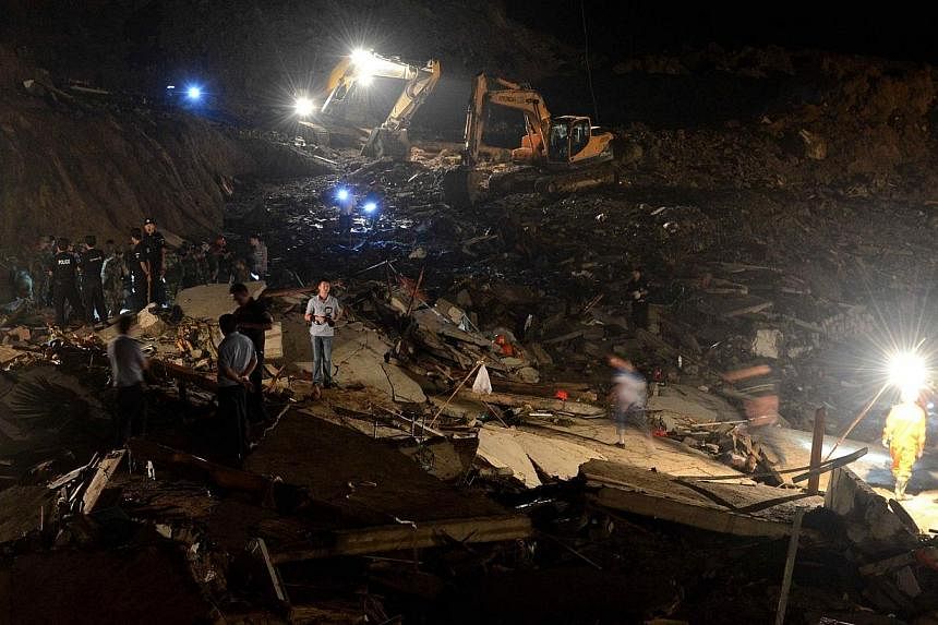 Rescuers search for survivors in the debris after a landslide in Fuquan, in southwest China's Guizhou province, on Aug 28, 2014. Eight people died and another 17 were left missing by a landslide in China, state media reported on Thursday. -- PHOTO: A