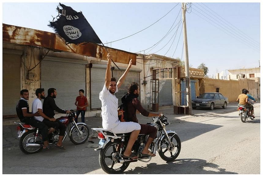A resident of Tabqa city touring the streets on a motorcycle waves an Islamist flag in celebration after militants from the Islamic State of Iraq and Syria (ISIS)&nbsp;took over Tabqa air base, in nearby Raqqa city, Syria, on Aug 24, 2014.&nbsp;Malay