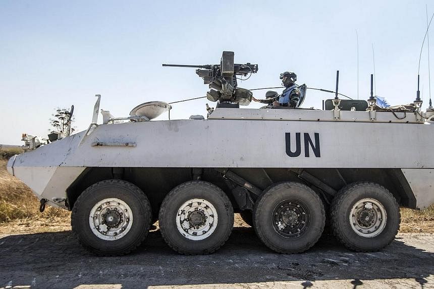 Irish members of the United Nations Disengagement Observer Force (UNDOF) sit on their armoured vehicles in the Israeli-annexed Golan Heights as they wait to cross into the Syrian-controlled territory on Thursday, Aug 28, 2014.&nbsp;A group of 43 Unit