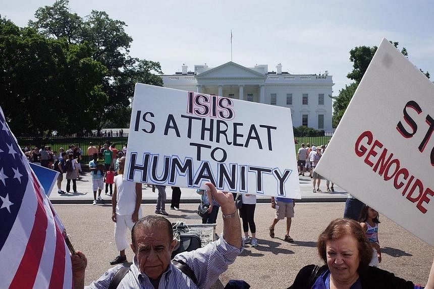 Demonstrators at a rally supporting Kurdistan hold placards protesting against the Islamic State of Iraq and Syria (ISIS) in front of the White House on Aug 16, 2014 in Washington, DC.&nbsp;-- PHOTO: AFP