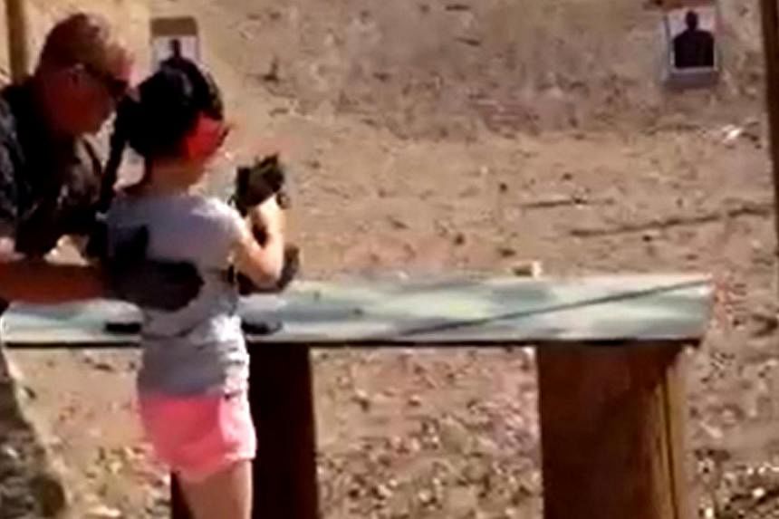 Shooting instructor Charles Vacca stands next to a 9-year-old girl at the Last Stop shooting range in White Hills, Arizona near the Nevada border, on Aug 25, 2014, in this still image taken from video courtesy of the Mohave County Sheriff's Office. T