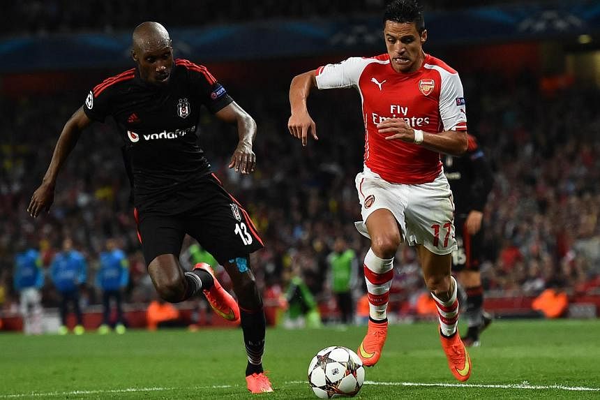 Arsenal's Chilean striker Alexis Sanchez (right) takes on Besiktas' Canadian midfielder Atiba Hutchinson (left) during the UEFA Champions League qualifying round play-off second-leg football match between Arsenal and Besiktas' at the Emirates Stadium