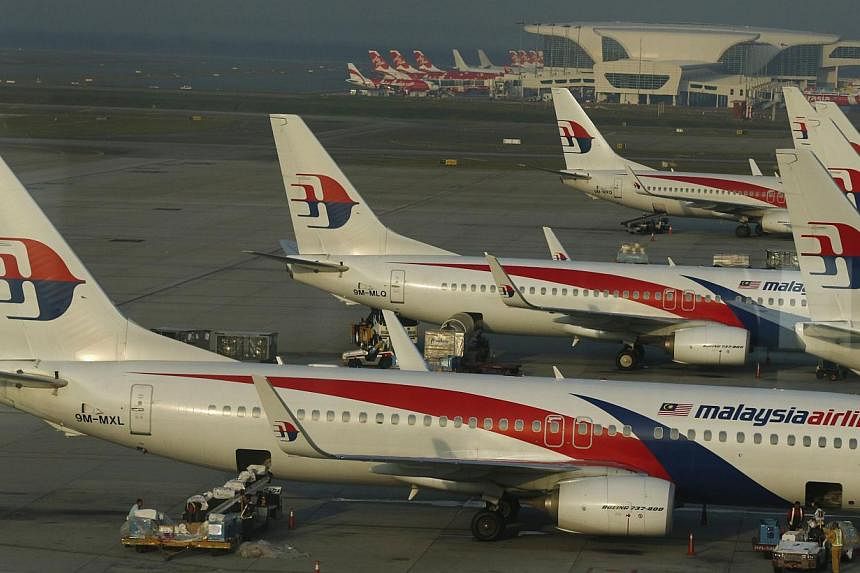 Ground crew work among Malaysia Airlines planes on the runway at Kuala Lumpur International Airport (KLIA) in Sepang on July 25, 2014. Malaysia has signed a memorandum of understanding (MOU) with Australia to strengthen their collaboration in the sea
