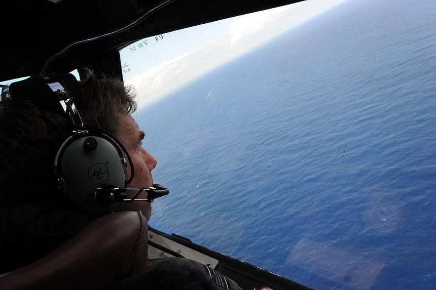 Squadron Leader Brett McKenzie of the Royal New Zealand Air Force searches for the missing Malaysia Airlines flight MH370, far off the coast of Perth, on April 13, 2014. -- PHOTO: AFP&nbsp;