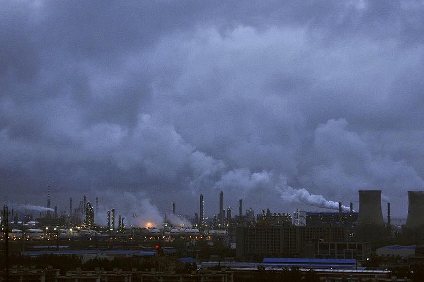 Smoke rises from chimneys and cooling towers of a refinery in Ningbo, Zhejiang province on Aug 19, 2014. -- PHOTO: REUTERS