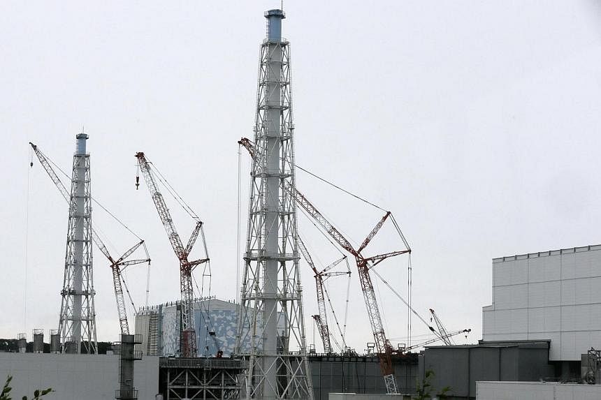 Cranes are seen at the No. 3 reactor building, next to the No.4 building, at Tokyo Electric Power Co.'s (Tepco) tsunami-crippled Fukushima Daiichi nuclear power plant in Fukushima Prefecture on July 9, 2014.&nbsp;A 400kg machine part fell into a nucl