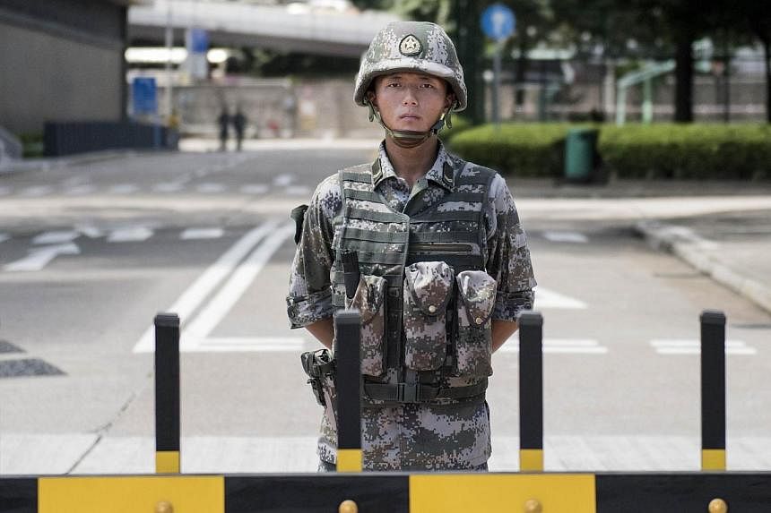 A Chinese People's Liberation Army (PLA) soldier stands guard at the entrance to the PLA's Hong Kong Garrison headquarters in Hong Kong on Aug 29, 2014.&nbsp;Hong Kong democracy advocates expressed alarm on Friday after Chinese army vehicles were pho