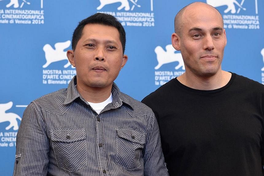 Adi Rukun poses with US director Joshua Oppenheimer during the photocall of the movie The Look Of Silence presented at the 71st Venice Film Festival on August 28, 2014 at Venice Lido. The movie is Oppenheimer's second documentary based on death squad