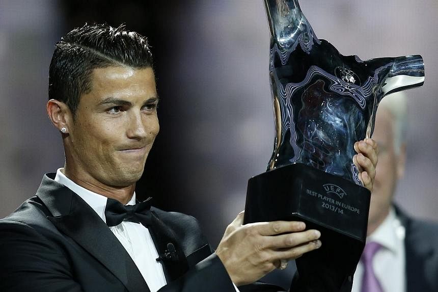 Real Madrid's Portuguese forward Cristiano Ronaldo celebrates holding his UEFA European Player of the Year trophy, on August 28, 2014 in Monaco, after the draw for the 2014/2015 European Champions League group stages. --PHOTO: AFP&nbsp;
