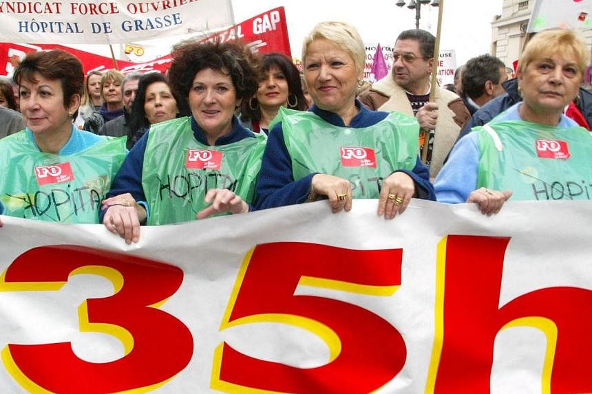 Thie file picture taken in 2002 shows hospital employees holding a banner reading "35 hours" while marching in Marseille on a national day of action organised by four trade unions. France's new Economy Minister Emmanuel Macron grabbed headlines after