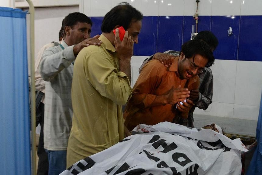 Relatives mourn over the dead body of a Pakistani journalist at a hospital following an attack by a gunman in Quetta on August 28, 2014. The gunman opened fire on the offices of a domestic private news agency in south-west Pakistan on Thursday, killi