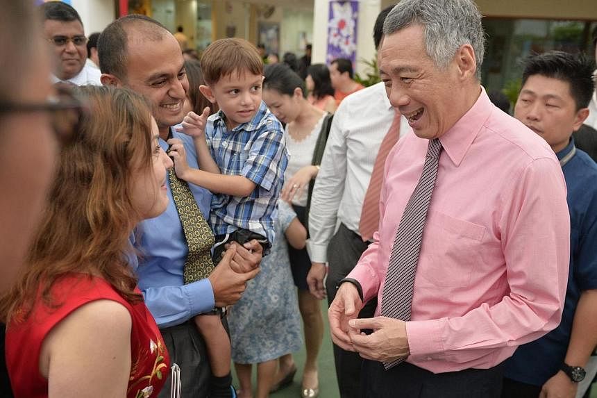 PM Lee Hsien Loong speaks to new Singapore citizens Rege Abhijit (left), 35, an owner of an engineering company, his wife Zlata Luneva (far left), 33, an assistant manager at a healthcare company, and their five-year-old son Vijay Rege,after the Ang 