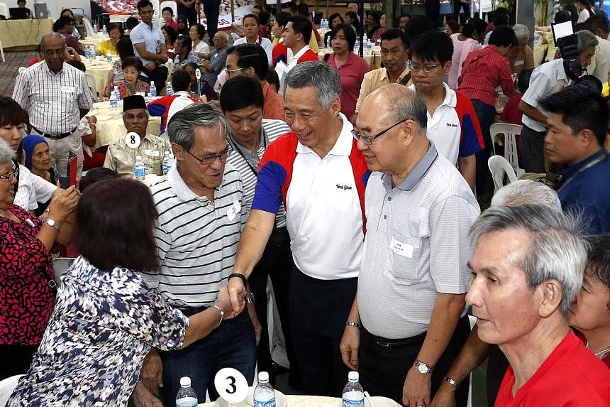 Prime Minister Lee Hsien Loong (centre) mingle with residents, who is also the MP for Ang Mo Kio GRC, presenting pioneer generation packages to pioneers.&nbsp;As Prime Minister Lee Hsien Loong presented Pioneer Generation cards to elderly constituent