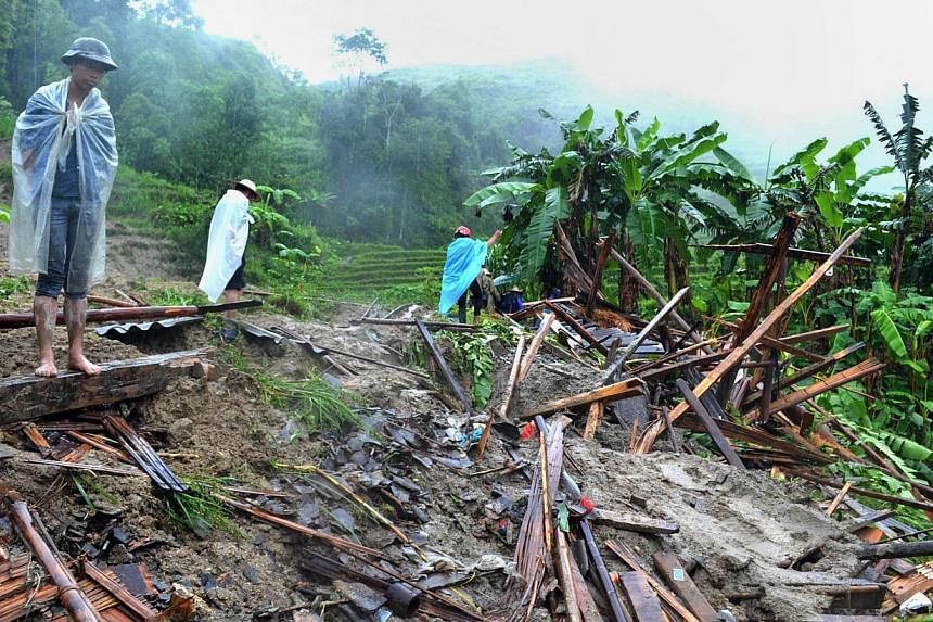 Locals looking at a destroyed house in a village hit by flash floods. Villagers say the weather has become so unpredictable in recent years. -- PHOTO: AGENCE FRANCE-PRESSE