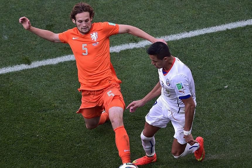 Netherlands' defender Daley Blind (left) vies with Chile's forward Alexis Sanchez during a Group B football match between Netherlands and Chile at the Corinthians Arena in Sao Paulo during the 2014 Fifa World Cup. -- PHOTO: AFP