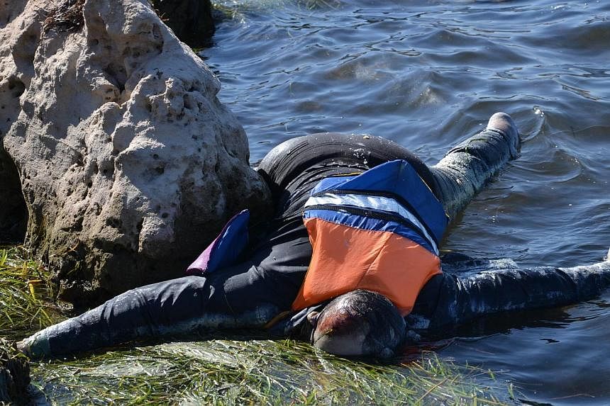 A picture taken on August 29, 2014 shows a body floating on the water after a boat carrying illegal migrants from Libya sank off the shores of the coastal town of Ben Guerdane, in south-east Tunisia.Tunisia rescuers recovered the bodies of at least 1