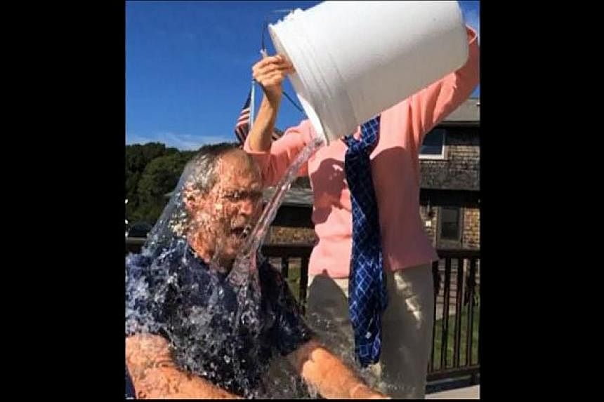Former US president George W. Bush taking part in the "Ice Bucket Challenge" in a still image taken from video on August 20, 2014. Bush posted video evidence of his soaking - carried out by wife Laura - on Facebook. -- PHOTO: REUTERS