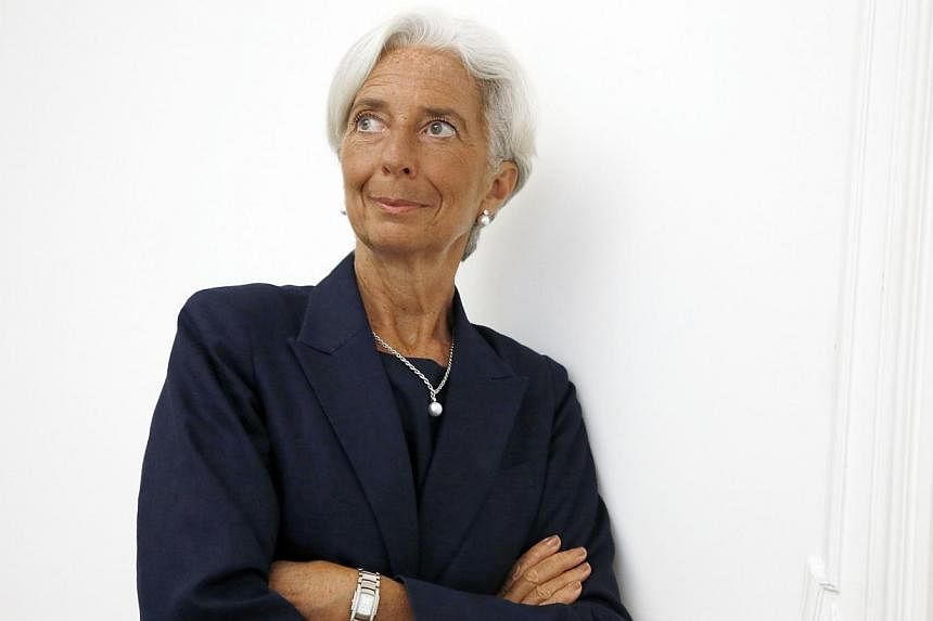 IMF chief Christine Lagarde poses on the sideline of a press conference on August 27, 2014 at her lawyer's office in Paris, after announcing she had been charged for "negligence" over a multi-million-euro corruption case relating to her time as Frenc