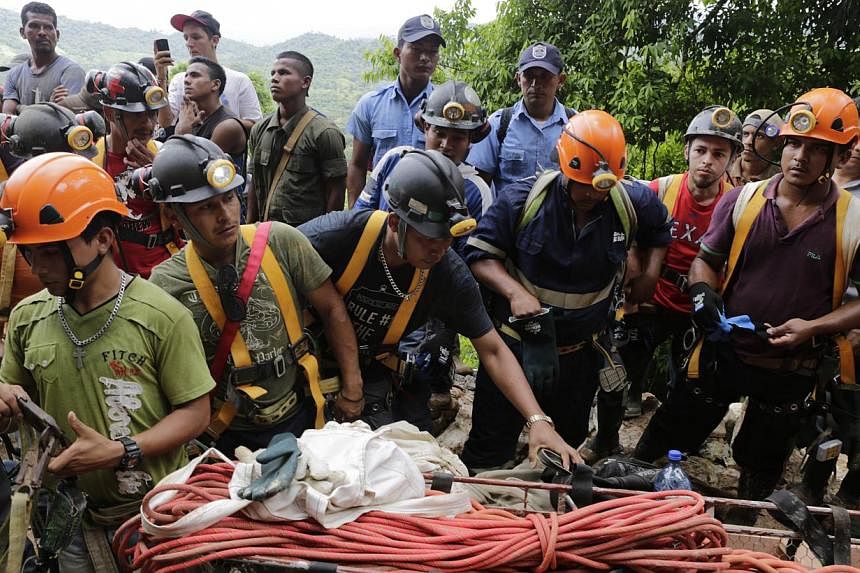 Miners help rescuers in their attempt to reach a group of fellow miners trapped in a gold mine in the community of El Comal, near Bonanza in northeastern Nicaragua, on August 29, 2014. At least 20 miners are trapped alive deep underground after an in