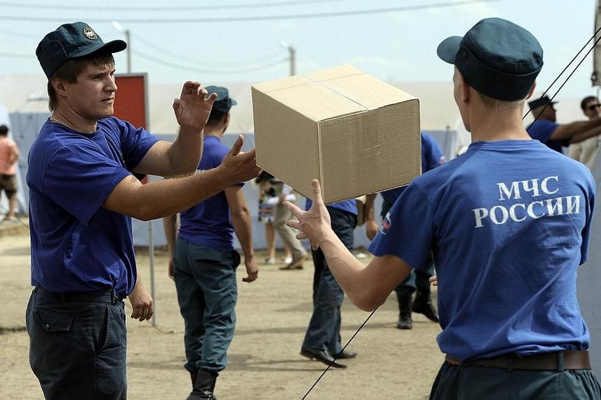 Employees of Russian Emergency Ministry carry boxes with humanitarian aid in a refugee camp for refugees from eastern Ukraine near the Russian city of Donets'k, Rostov region, about 15 kilometres from the Russian-Ukrainian border. -- PHOTO: AFP