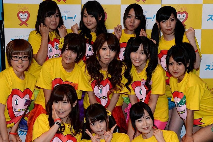 Nine Japanese porn actresses, (middle left-right) Kotone Nishida, Iku Sakuragi, Rina Serino, Yui Kasugano and Nodoka Otsuka, (rear left-right) Yuria Kitahara, Riku Nekota, Yumena Muro and Karin Natsumi, pose with three supporters (front) in Tokyo on 