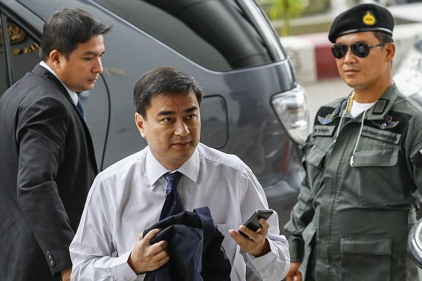 Democrat Party leader and former Thai prime minister Abhisit Vejjajiva (centre) arrives at a Bangkok criminal court on June 23, 2014.&nbsp;Thai police on Sunday, Aug 31, 2014, arrested at least two people for distributing leaflets demanding renewed l