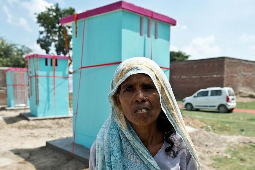 Indian villager Premwati Devi poses in front of newly-built toilets by NGO Sulabh International at Katra Sahadatgunj village in Badaun on Aug 31, 2014.&nbsp;More than 100 new toilets were unveiled Sunday in a poverty-stricken and scandal-hit village 