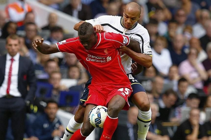 Liverpool's Mario Balotelli (left) shields the ball from Tottenham Hotspurs' Younes Kaboul during their English Premier League football match at White Hart Lane in London on Aug 31, 2014.&nbsp;-- PHOTO: REUTERS