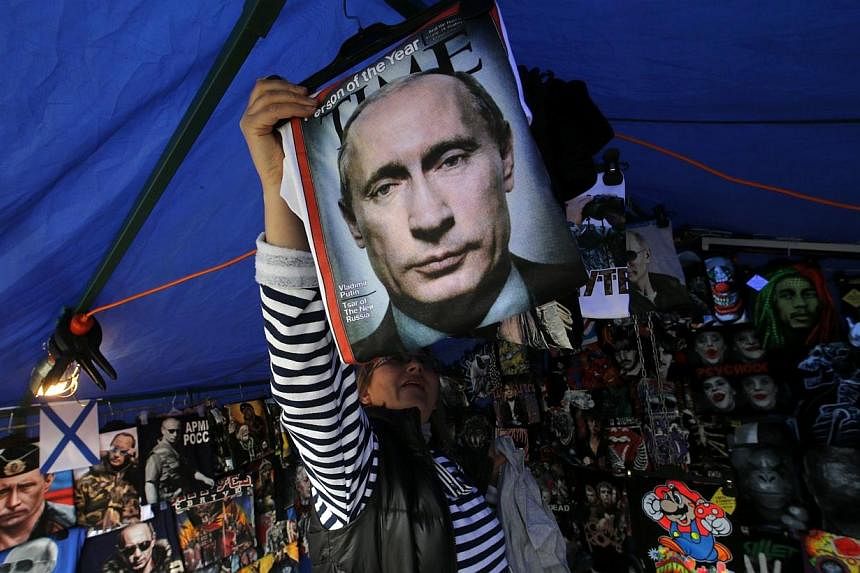 A vendor sells T-shirts printed with images of Russia's President Vladimir Putin at a street store in the center of St. Petersburg, on Aug 31, 2014.&nbsp;Russian President Vladimir Putin called on Sunday for immediate talks on the future of war-torn 