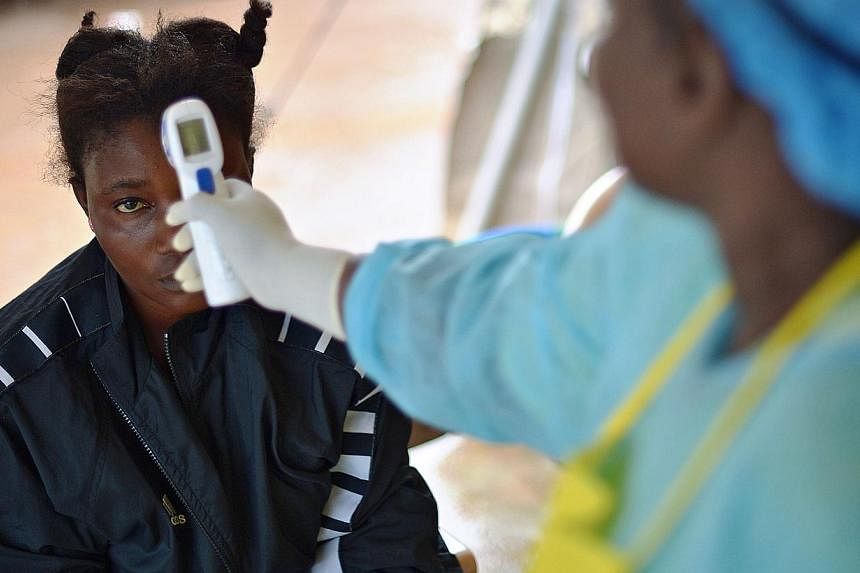A girl suspected of being infected with the Ebola virus has her temperature checked at the government hospital in Kenema, Sierra Leone, on August 16, 2014.&nbsp;&nbsp;Health workers at a major state-run Ebola treatment centre in Sierra Leone said on 