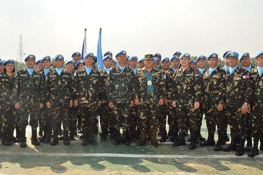 A handout photo taken in October 2013 and released by Philippine Armed Forces public affairs office on August 29, 2014 shows officers and men of the 7th Philippine peacekeeping force bound for the Golan Heights posing for photos during their send-off