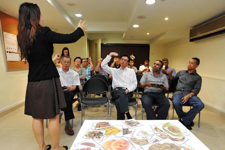 Health Promotion Board trainer Elaine Wong conducting a Healthy Tasty Food Workshop for SMRT taxi drivers at the SMRT Taxis Customer Service Centre on Monday, Sept 1, 2014.&nbsp;-- ST PHOTO: LIM YAOHUI