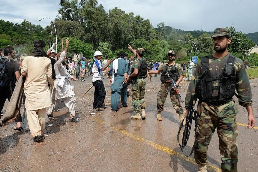 Pakistani army soliders disperse protestors after clashes with anti-government demonstrators and police near the prime minister's residence in Islamabad on Sept 1, 2014.&nbsp;Pakistani soldiers and paramilitary forces entered the headquarters of the 