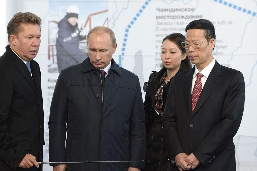 Russia's gas giant Gazprom CEO, Alexei Miller (left), Russian President Vladimir Putin (2nd from left) and Vice Premier of the People's Republic of China Zhang Gaoli (right) attend the ceremony marking the welding of the first link of "The Power of S