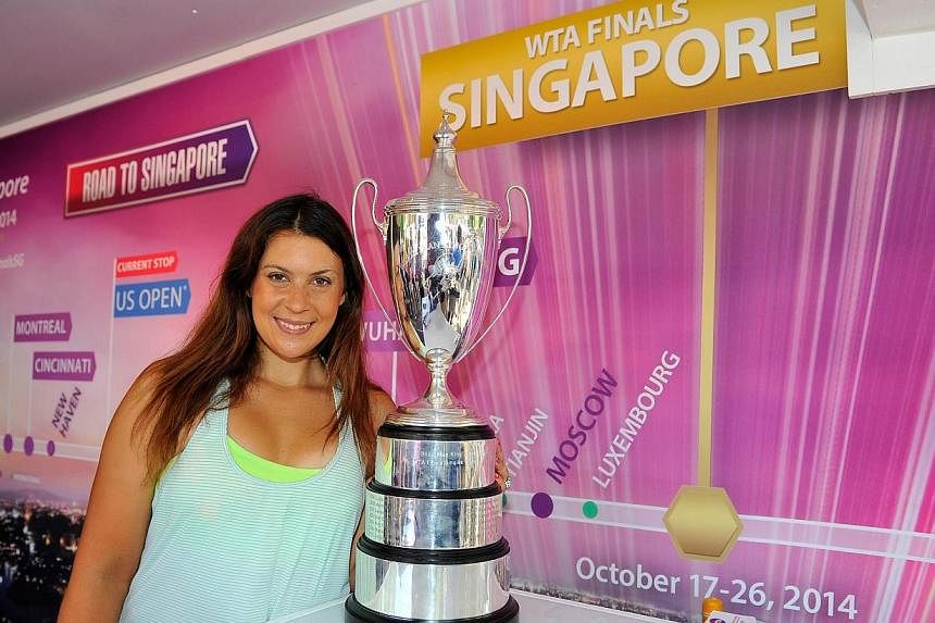 Marion Bartoli poses with the WTA Billie Jean King Trophy on Day Three of the 2014 US Open at the USTA Billie Jean King National Tennis Center on Aug 27, 2014 in the Flushing neighborhood of the Queens borough of New York City. Bartoli will play in t
