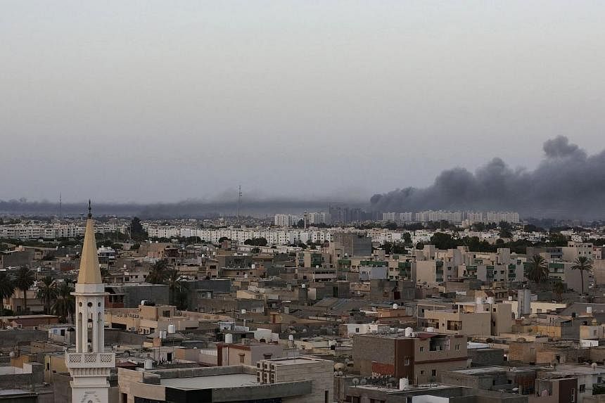 Plumes of black smoke (right) is seen after war planes struck Misrata positions in Tripoli in an attack claimed by renegade general Khalifa Haftar, on Aug 23, 2014.&nbsp;Libya's government said it has lost control of most ministries and state institu