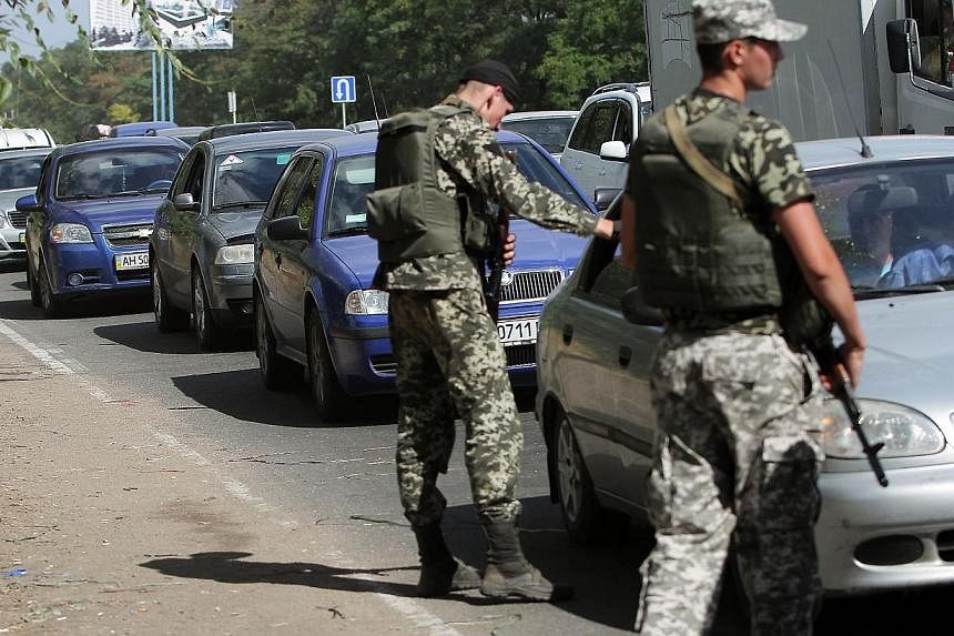 Ukranian troops stopping cars at a checkpoint in Mariupol, in the Donetsk region, last Saturday. Geo-political uncertainties, coupled with questions over emerging markets and the many local companies missing earnings forecasts, could bring trading or