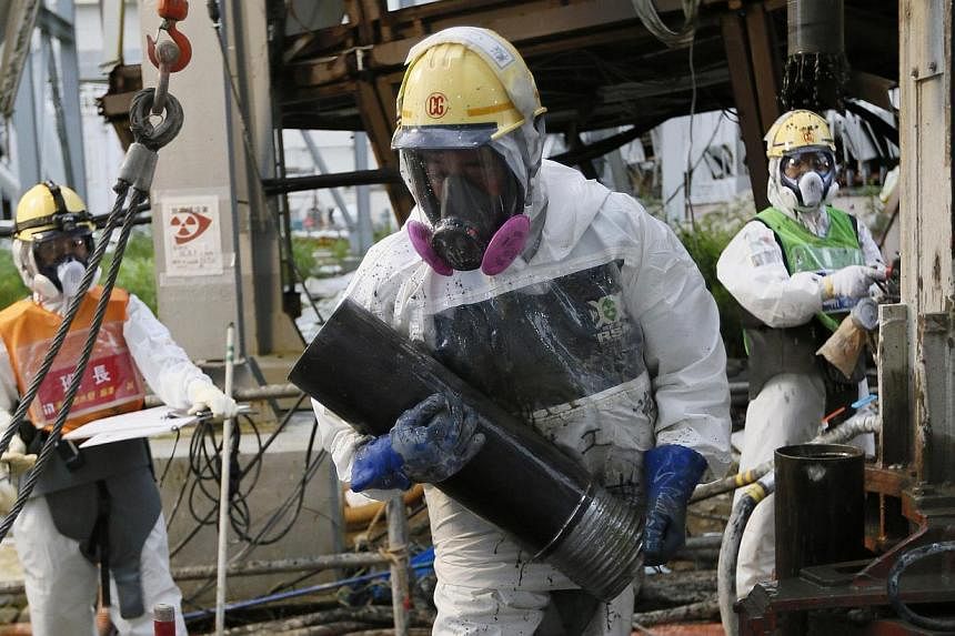 Workers conduct operations to construct an underground ice wall at Tokyo Electric Power Co.'s (Tepco) tsunami-crippled Fukushima Daiichi nuclear power plant in Fukushima Prefecture on July 9, 2014.&nbsp;The governor of disaster-struck Fukushima agree