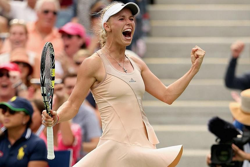 Caroline Wozniacki of Denmark celebrates match point against Maria Sharapova of Russia after winning their women's singles fourth round match on Day Seven of the 2014 US Open at the USTA Billie Jean King National Tennis Center in the Flushing neighbo