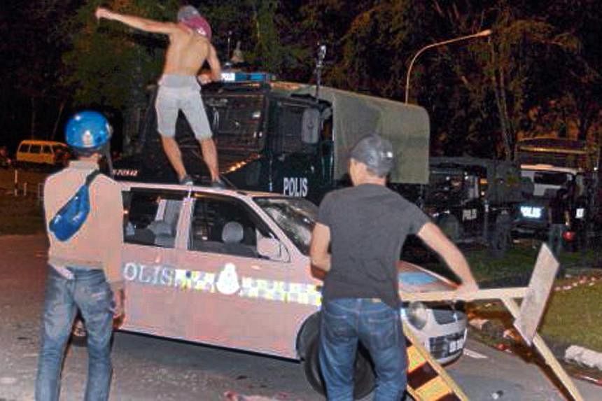 Rioters damaged police vehicles during the riot. -- PHOTO: NSTP