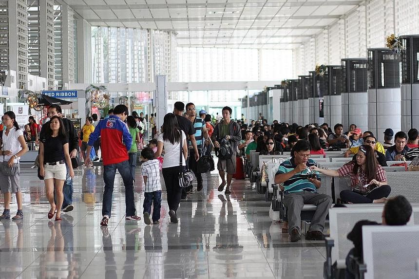 Passengers wait in Terminal 2 of Ninoy Aquino International Airport (NAIA) in Manila, the Philippines. -- PHOTO: EDWIN TUYAY