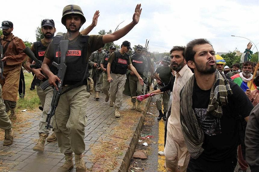 Soldiers from the Pakistan Rangers stop supporters of Tahir ul-Qadri, Sufi cleric and leader of political party Pakistan Awami Tehreek (PAT), during Revolution March towards the prime minister's house in Islamabad. -- PHOTO: REUTERS