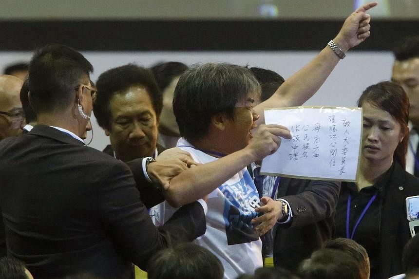 Pro-democracy lawmaker Leung Kwok-hung is blocked by security guards as he protests against Li Fei (not pictured), deputy general secretary of the National People's Congress (NPC) standing committee, as Li speaks on the podium during a briefing sessi