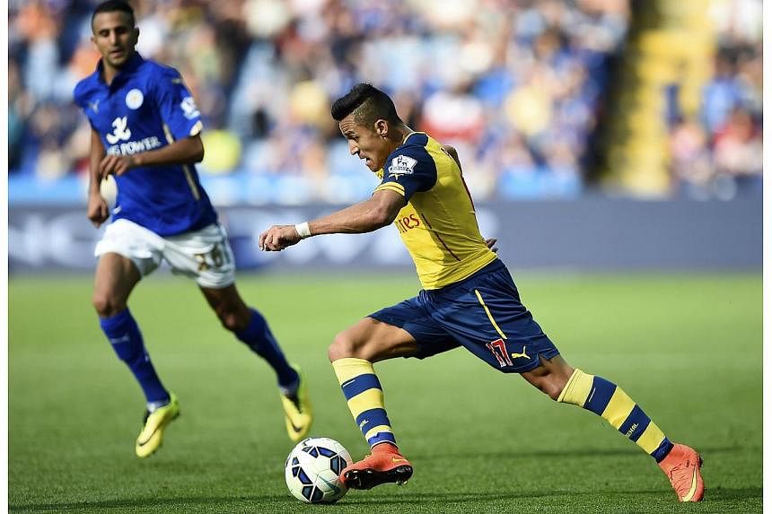 Arsenal's Alexis Sanchez (right) runs with the ball during their English Premier League soccer match against Leicester City at the King Power Stadium in Leicester, northern England on Aug 31, 2014. -- PHOTO: REUTERS