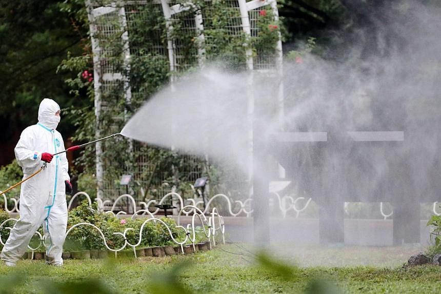 This picture taken on August 28, 2014 shows a worker spraying insecticide at the Yoyogi park, one of the largest open spaces in central Tokyo, believed to be the source of the mosquito-borne dengue fever. -- PHOTO: AFP&nbsp;