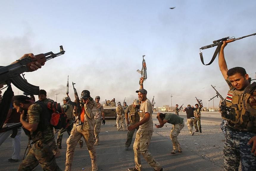 Iraqi Shiite militia fighters fire their weapons as they celebrate breaking a long siege of Amerli by Islamic State militants on Sept 1, 2014.&nbsp;-- PHOTO: REUTERS